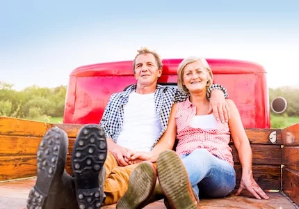 senior couple sitting in truck bed
