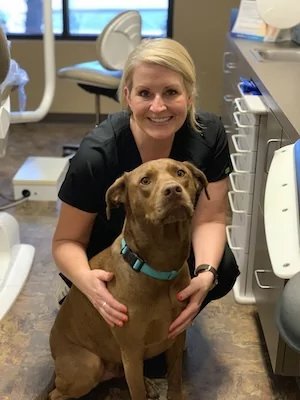 Vaca Dental team member posing for a photo with a dog