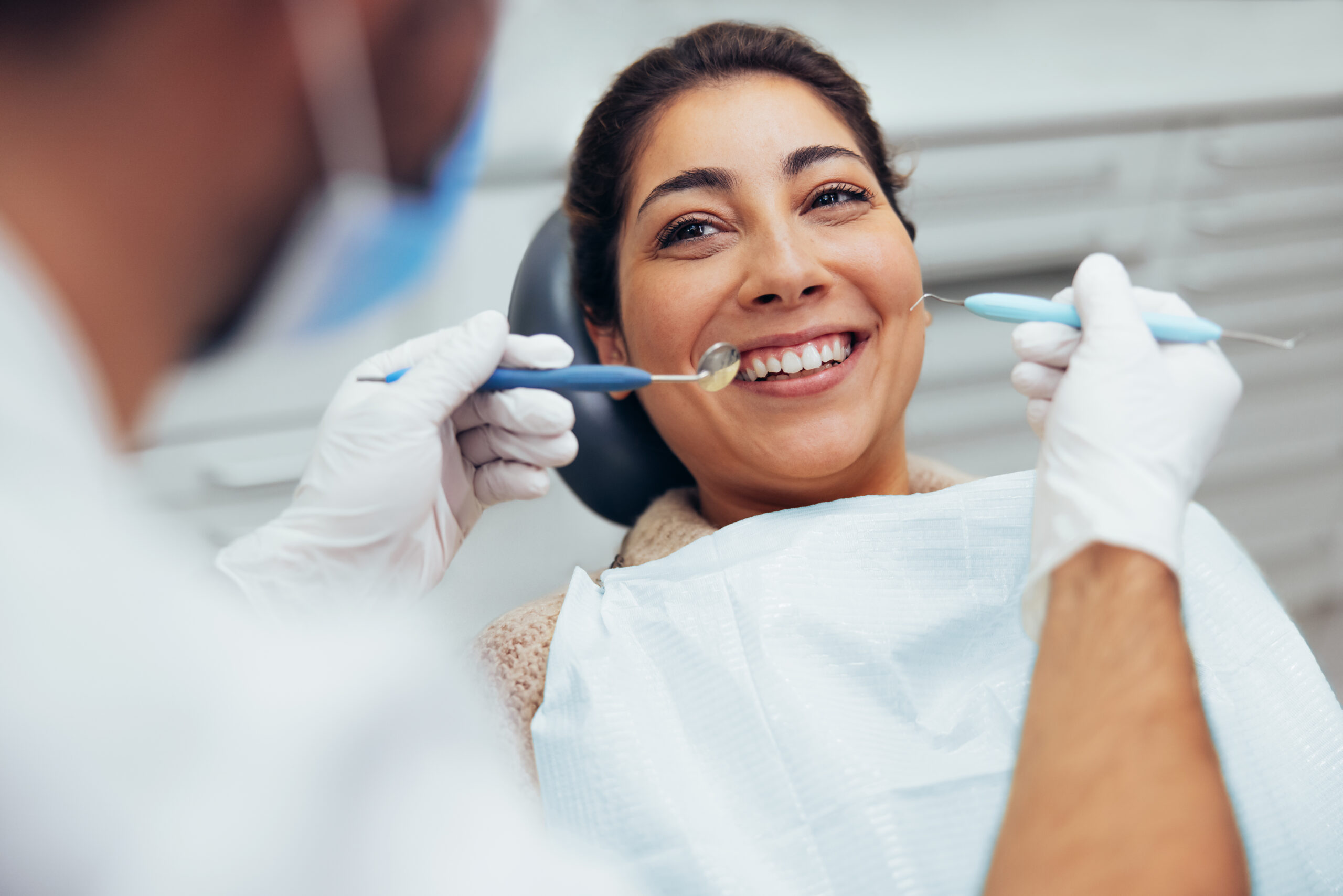 Over the shoulder view of a dental doctor treating female patient.