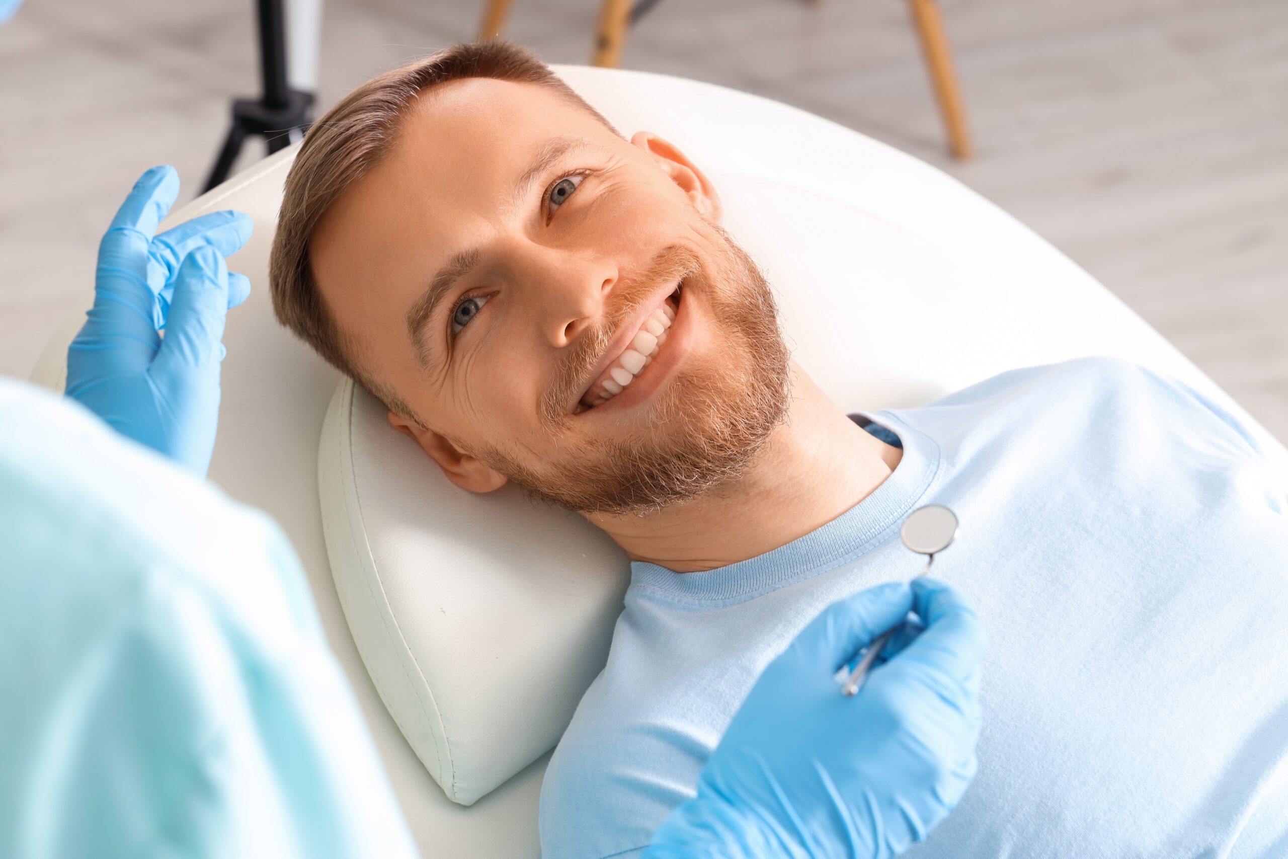 closeup of a young man smiling, getting a dental checkup